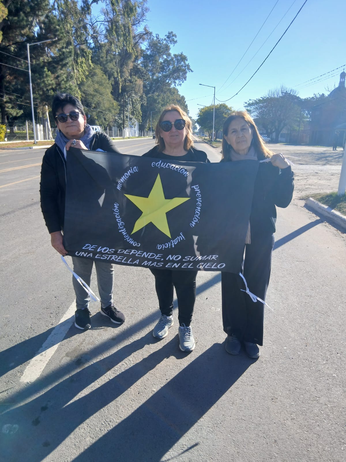Integrantes de Estrellas Amarillas Goya sosteniendo la bandera de la organización en la calle